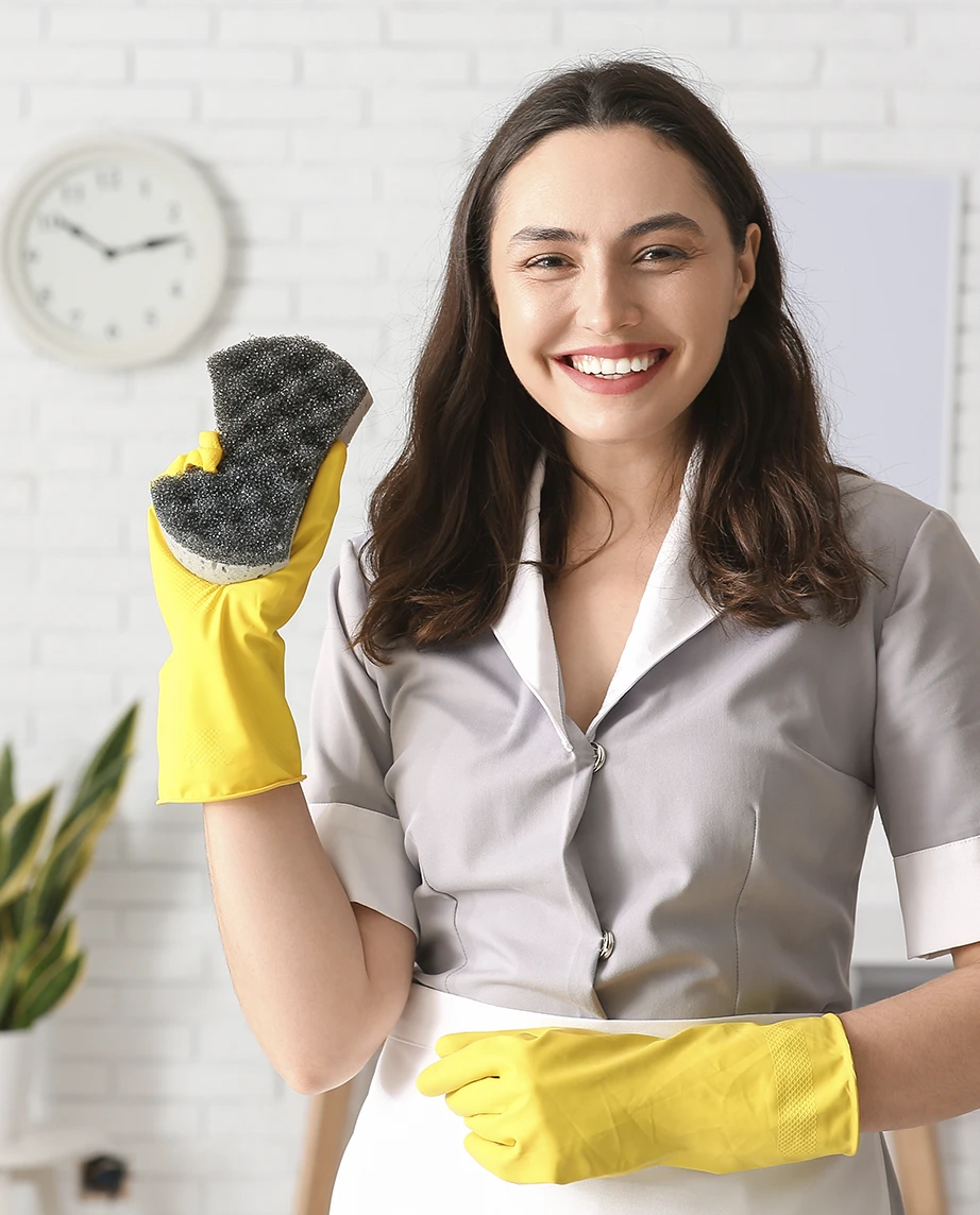 empregada doméstica sorridente, com luvas e um esfregão na mão