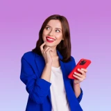 Senhora com ar feliz e a segurar um telemóvel