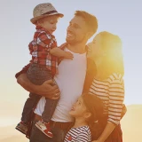 Família feliz com dois filhos no por do sol