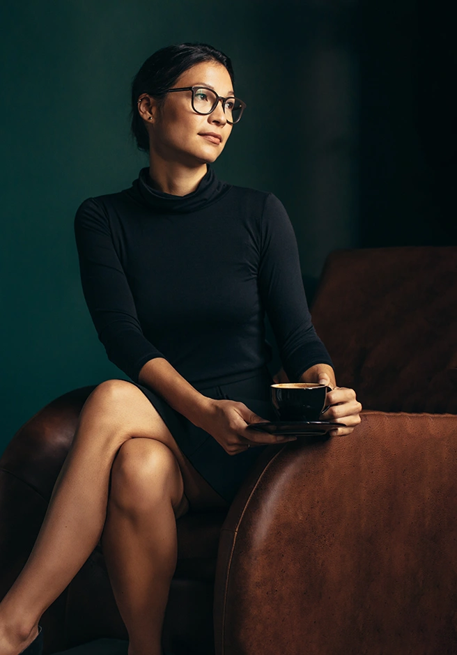 woman sitting on the sofa with a cup in her hand