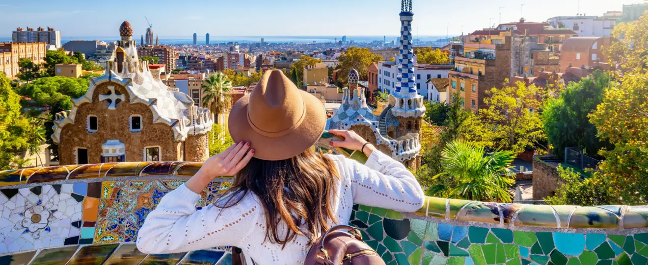 Mulher com chapéu observa a cidade de Barcelona a partir do Parque Güell