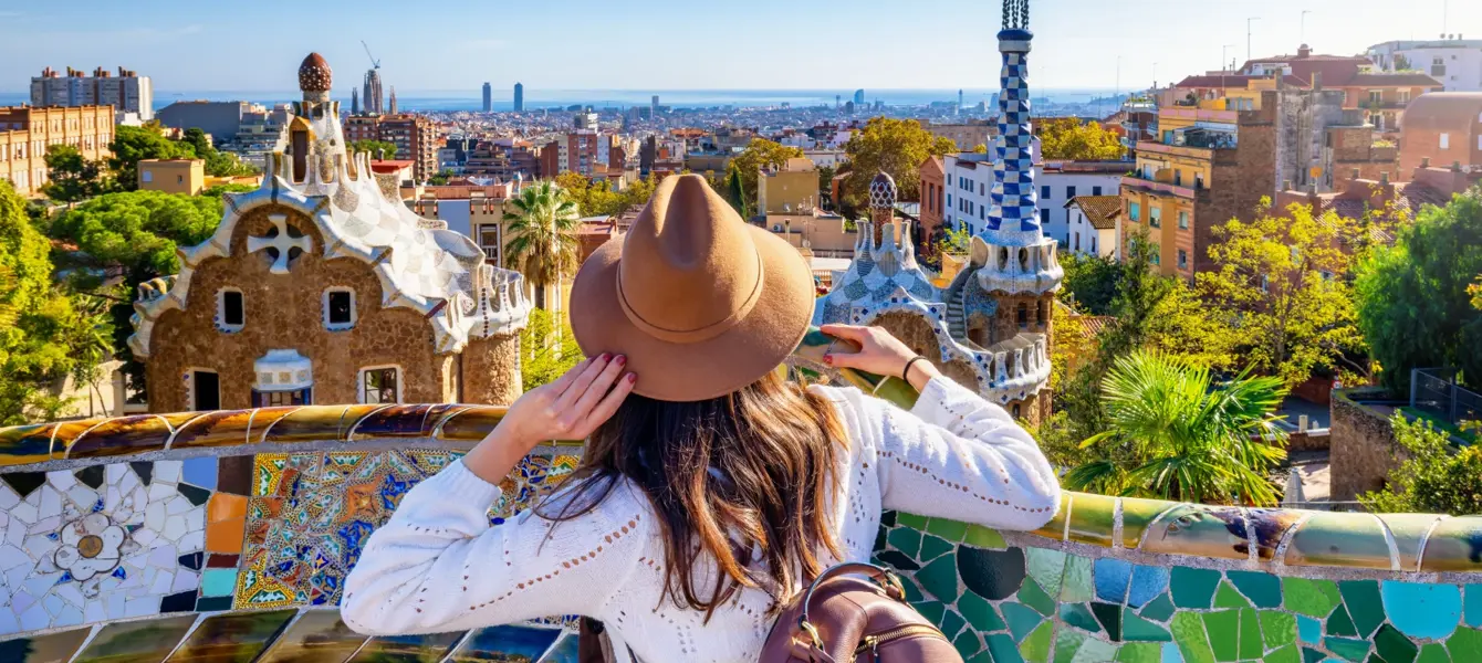 Mulher com chapéu observa a cidade de Barcelona a partir do Parque Güell