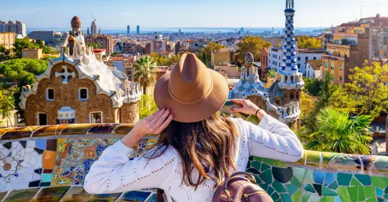 Mulher com chapéu observa a cidade de Barcelona a partir do Parque Güell