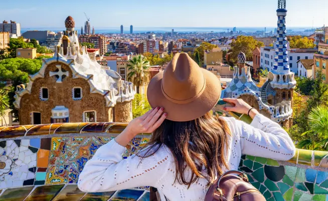 Mulher com chapéu observa a cidade de Barcelona a partir do Parque Güell