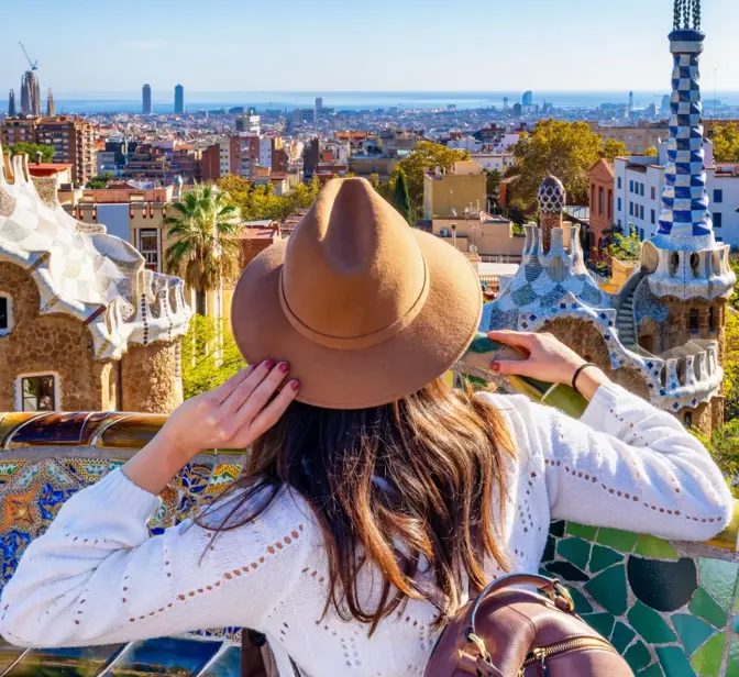 Mulher com chapéu observa a cidade de Barcelona a partir do Parque Güell