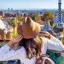 Mulher com chapéu observa a cidade de Barcelona a partir do Parque Güell