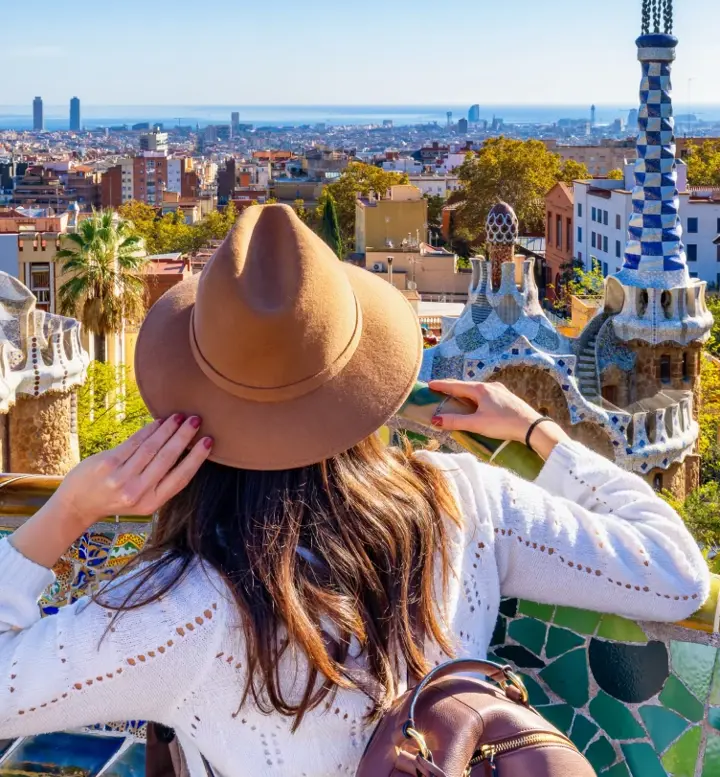 Mulher com chapéu observa a cidade de Barcelona a partir do Parque Güell
