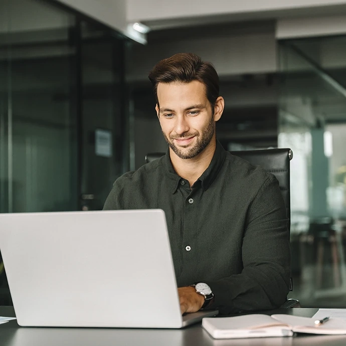 Homem a trabalhar no computador portátil num escritório