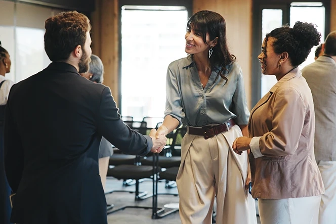 Homem e mulher apertam a mão num evento de networking
