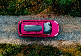 Carro a andar numa estrada com árvores dos dois lados