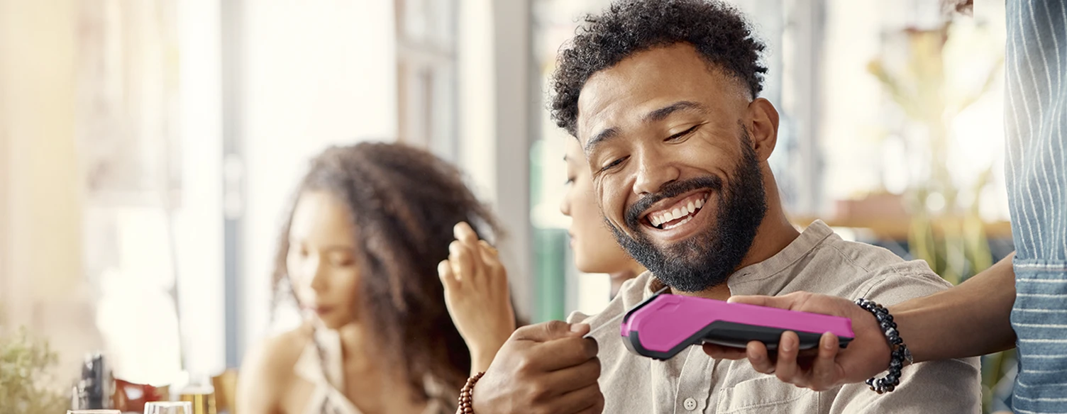 homem a pagar conta num restaurante, usando cartão contactless num TPA