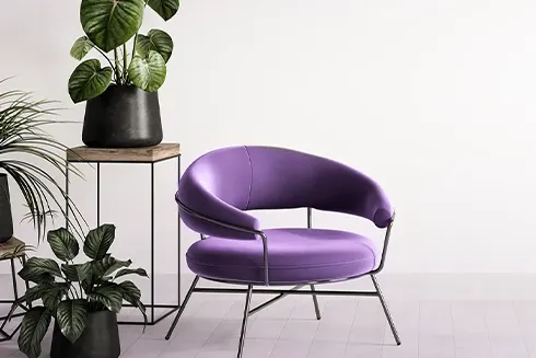 cadeira de design, roxa, em frente a vasos com plantas