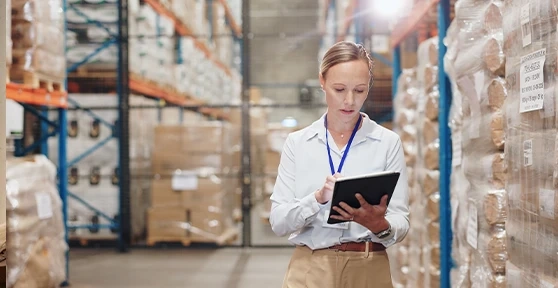 Mulher a verificar o inventário de um armazém num tablet