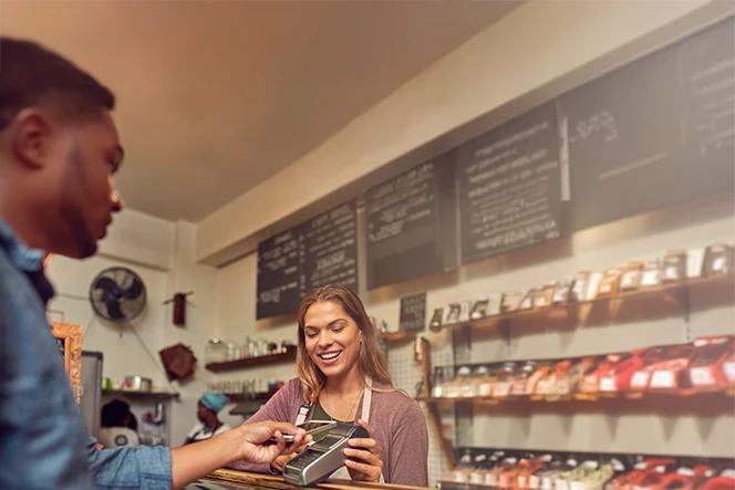 homem a pagar com cartão num TPA, num café