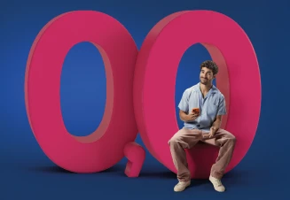 José Condessa holding a smartphone, sitting on a number zero, part of the figure 0.0