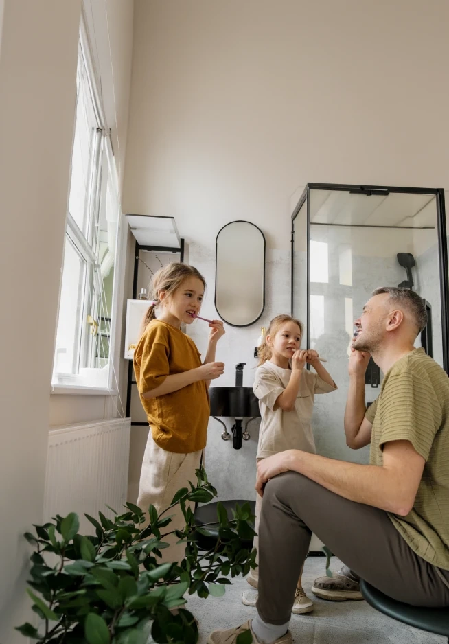 Pai com filhos a escovar os dentes