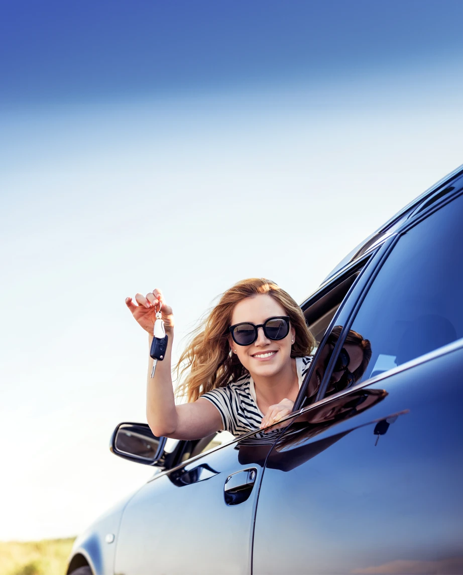 woman in sunglasses, looking out ou car window, holding keys