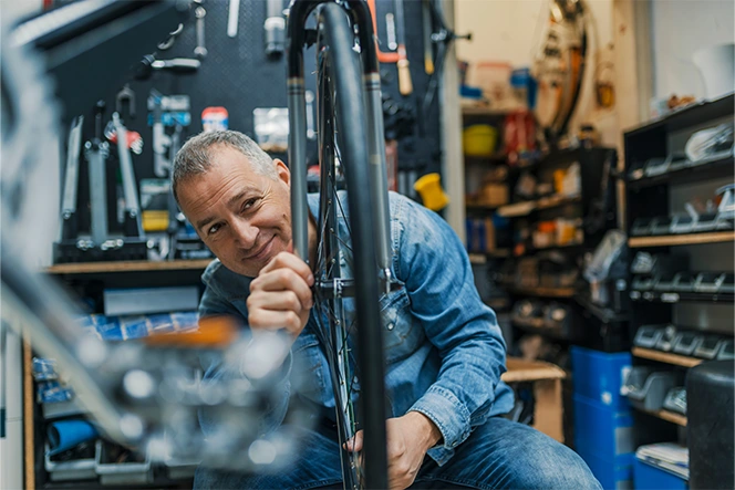 Senhor a reparar uma roda de bicicleta