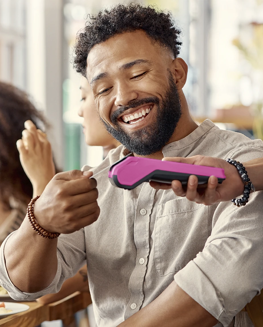 homem a pagar conta num restaurante, usando cartão contactless num TPA