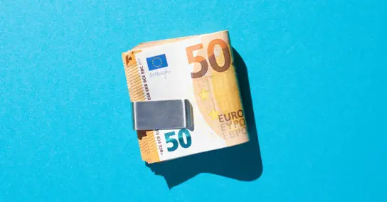 Maço de notas de 50 euros presas por um clipe de dinheiro em fundo azul