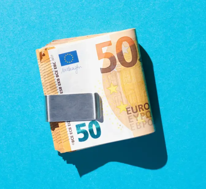 Maço de notas de 50 euros presas por um clipe de dinheiro em fundo azul