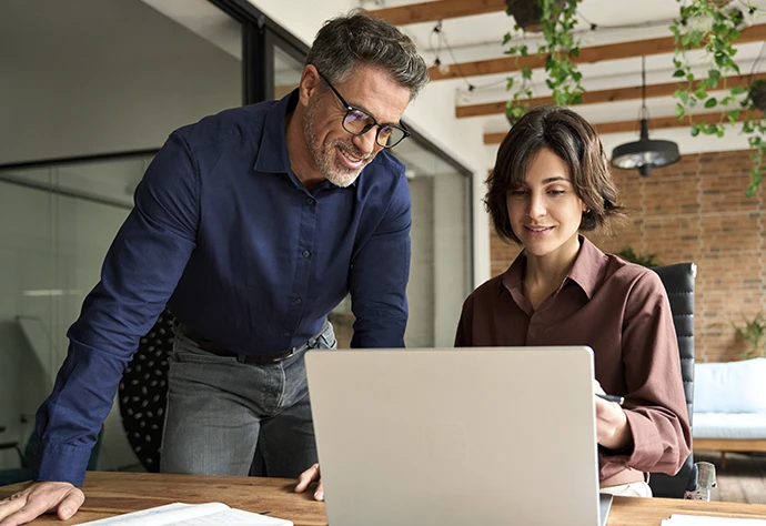 homem e mulher num escritório, a olhar para computador