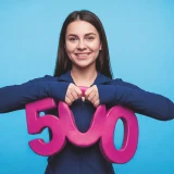 Smiling young man holding the number 500
