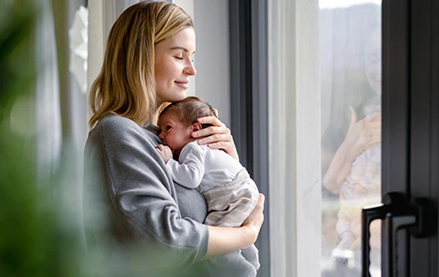 mãe feliz com bebé nos braços