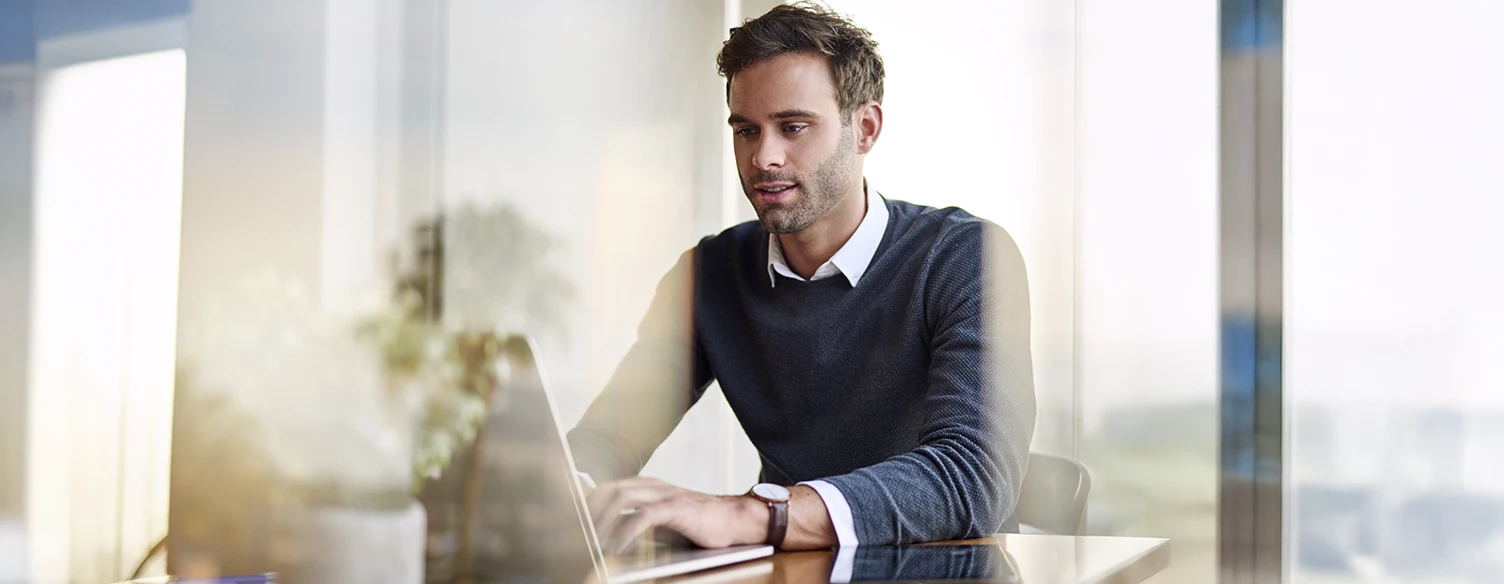Man sitting in an office, working on a computer