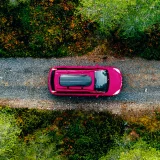 Carro a andar numa estrada com árvores dos dois lados