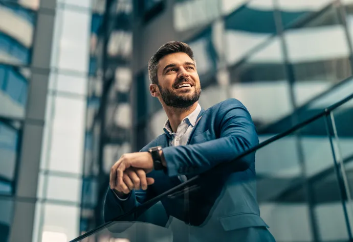 homem de negócios, sorridente, apoiado numa varanda