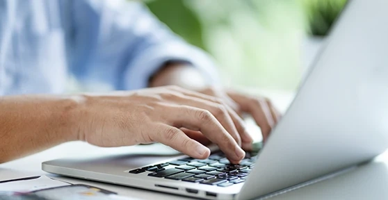 Pessoa a escrever num computador portátil