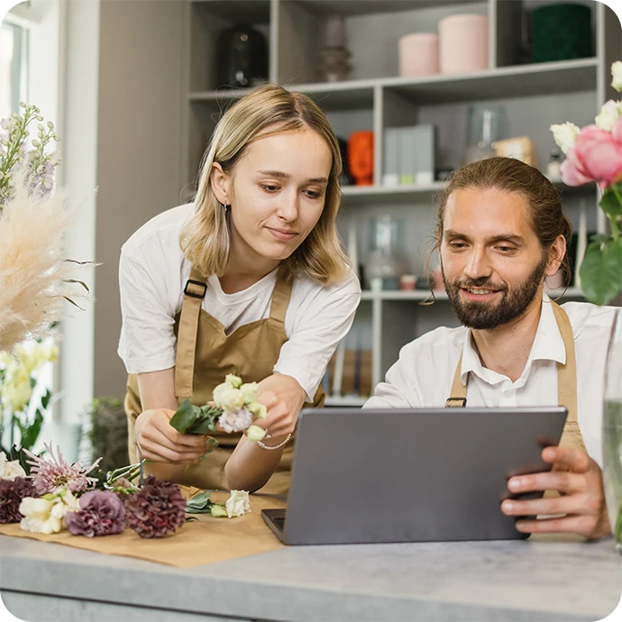 casal a trabalhar numa loja de flores, a ver computador