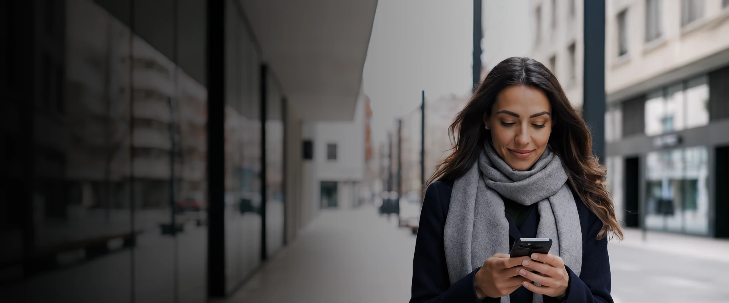 Mulher na rua a usar smartphone, com cachecol e casaco