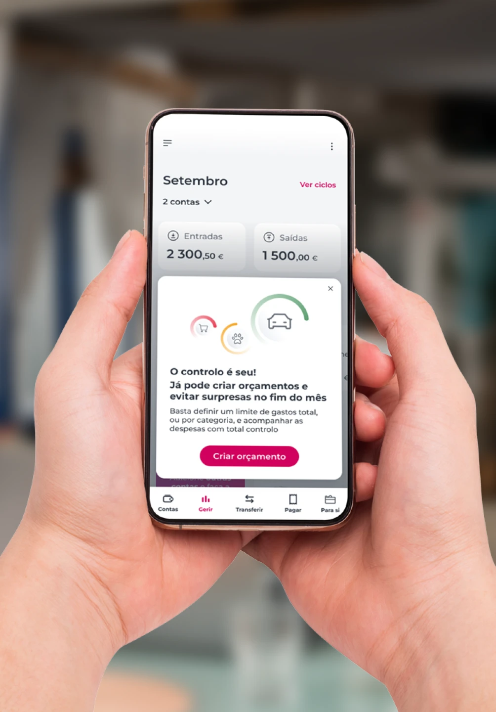 Telemóvel com um ecrã da App Millennium da área Gerir, com o texto "O controlo é seu! Já pode criar orçamentos e evitar surpresas no fim do mês" e o botão "Criar orçamento"
