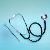 Estetoscópio e martelo de reflexos sobre fundo azul claro