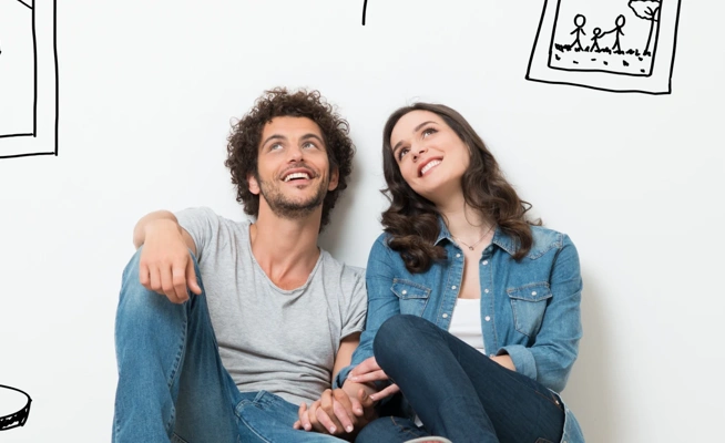 Casal jovem sentado no chão a imaginar a decoração da sua casa