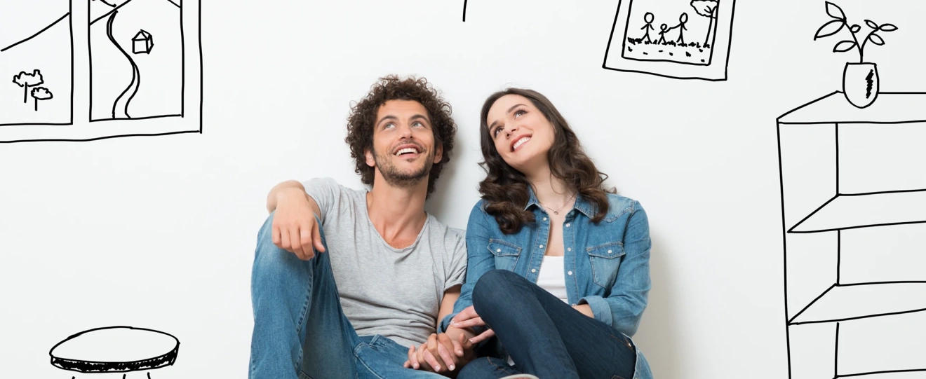 Casal jovem sentado no chão a imaginar a decoração da sua casa
