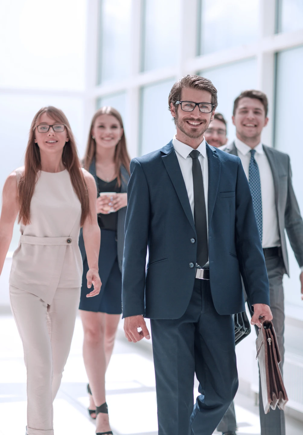 Equipa de 5 pessoas a andar no corredor do seu trabalho