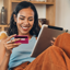 Mulher sorridente a fazer compras online num tablet com um cartão de crédito