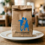 Saco de papel do Banco Alimentar contra a fome numa mesa de madeira
