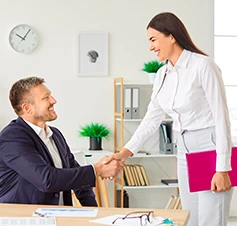 Homem e senhora num escritório a dar um aperto de mão