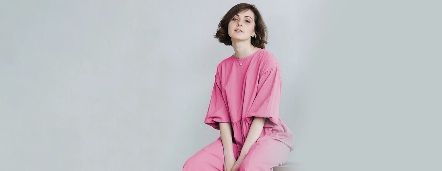 lady dressed in pink, sitting and smilling