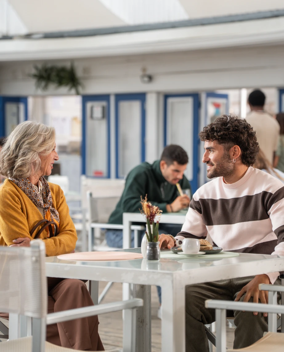 Custódia Gallego, a representar a personagem Fernanda Guimarães, e o José Condessa a conversarem num bar de praia