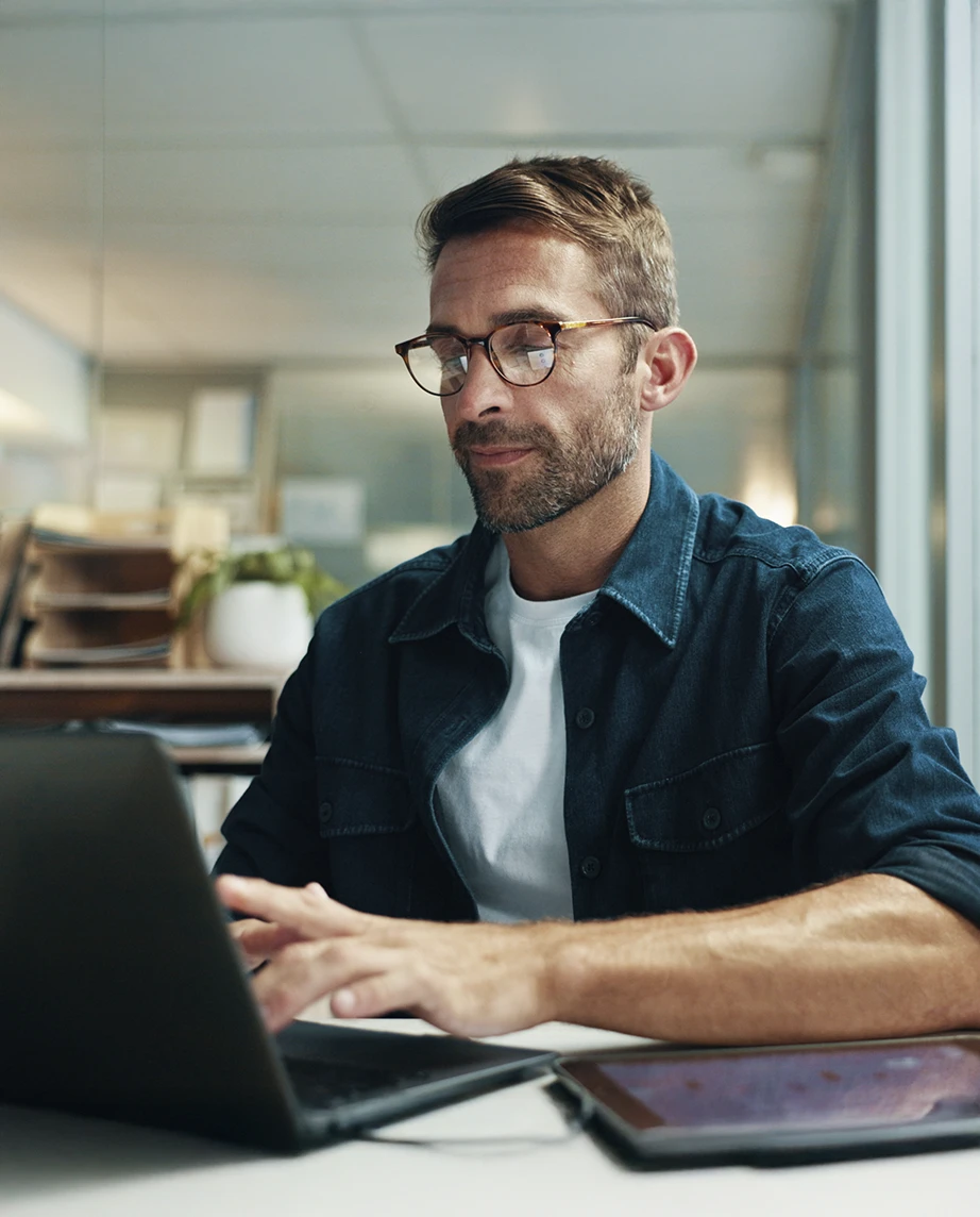 homem sentado, a trabalhar num computador, na sua sala