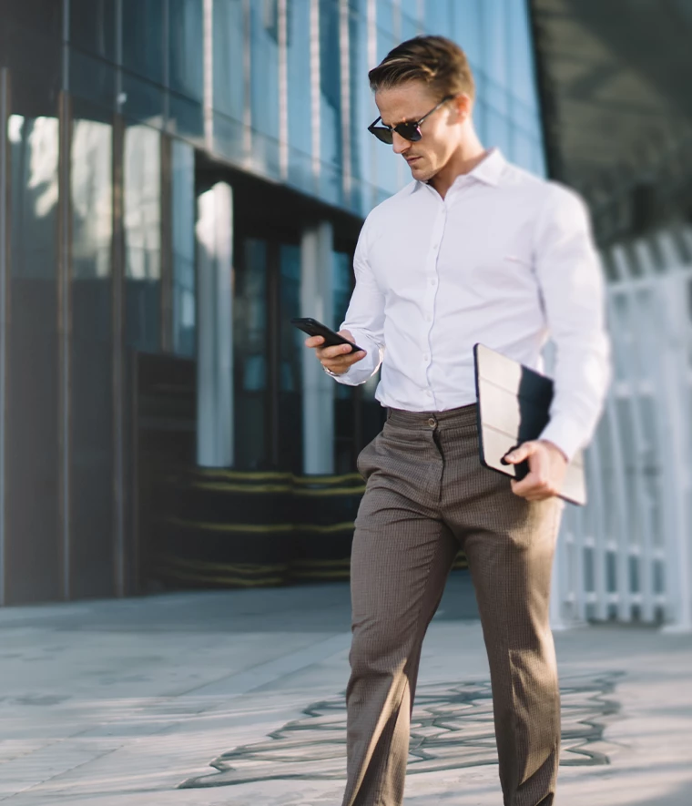 man in a suit, standing, looking at phone