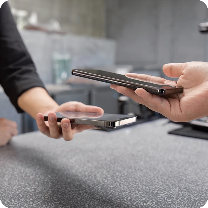 mãos a segurar telemóveis, um em cima do outro