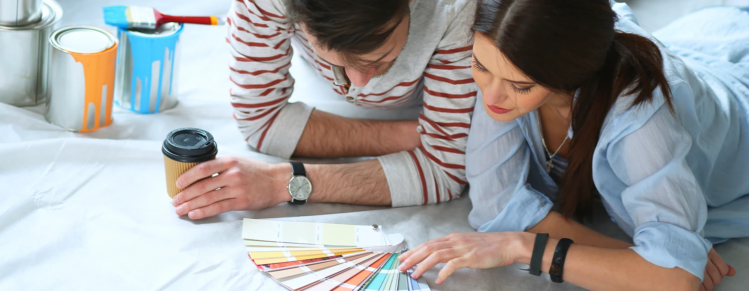 couple lying on the floor, choosing the paint color for the walls of their house