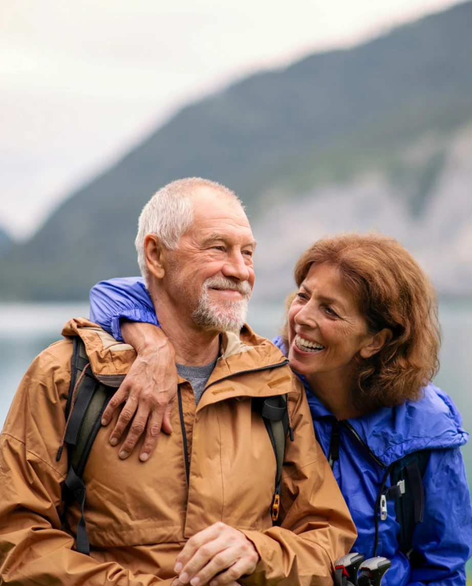 casal maduro a passear junto a lago e montanha