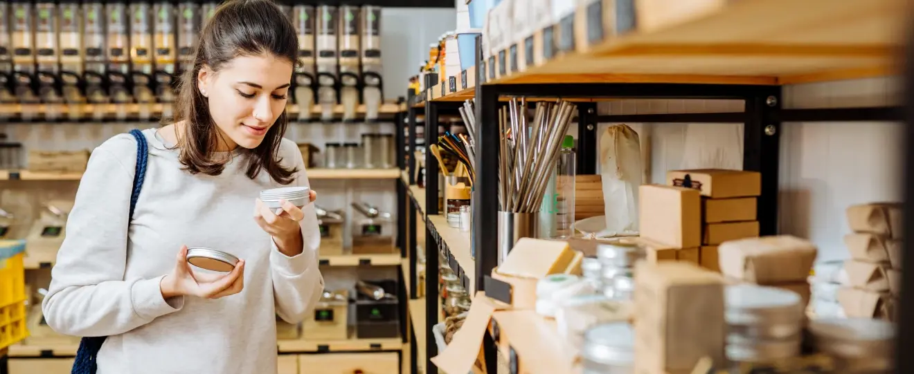 Mulher a cheirar produto numa loja de produtos a granel ou ecológicos
